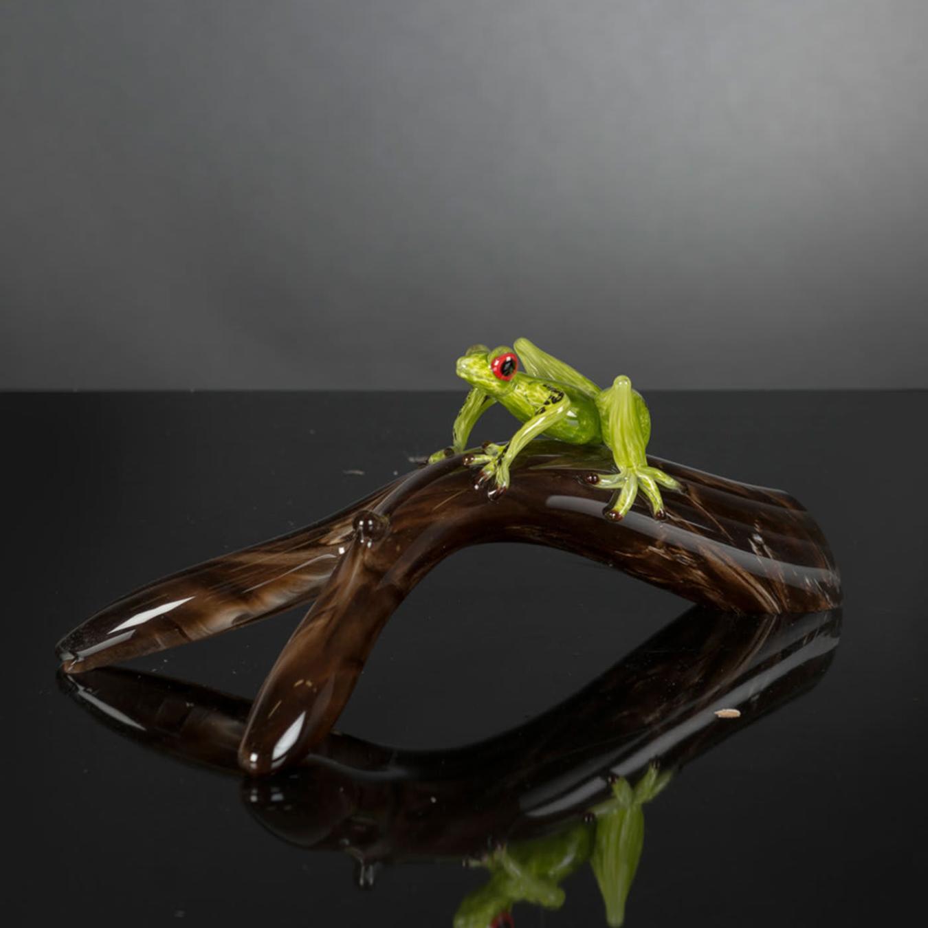 Figurine grenouille en verre sur branche